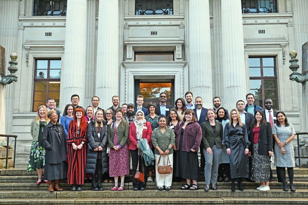The Welsh Crucible 2026 cohort, standing together on the steps of the Glamorgan building, smiling at the camera. 